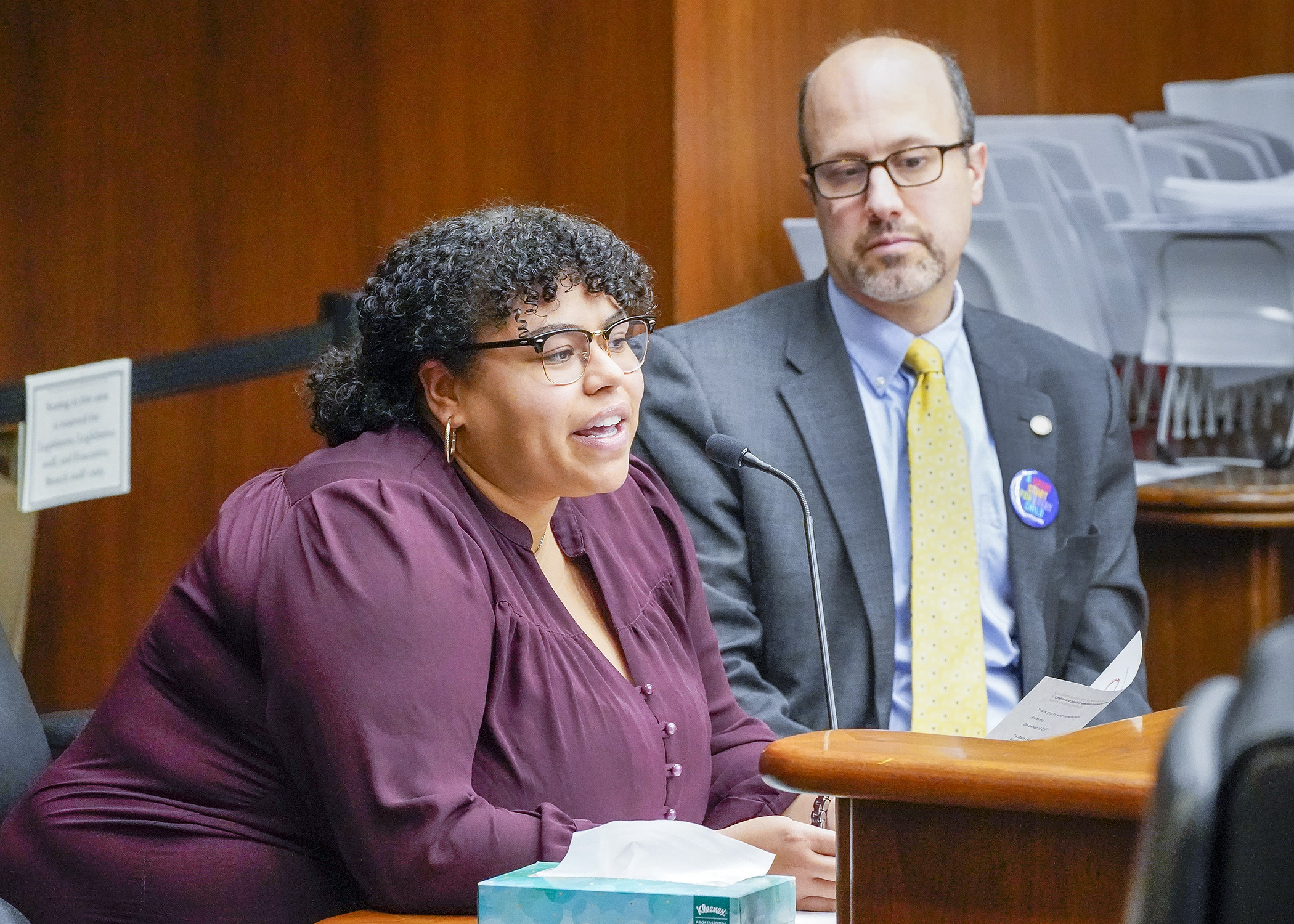 Ta’Mara Hill, policy officer for The Center for Victims of Torture, testifies before the House Public Safety Finance and Policy Committee March 2 in support of HF1233 sponsored by Rep. Dave Pinto, right. (Photo by Andrew VonBank)